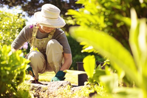 Gardener trimming a suburban front garden in Seven Kings
